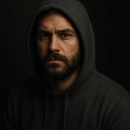 Portrait of a man in a hood on a black background.の写真素材