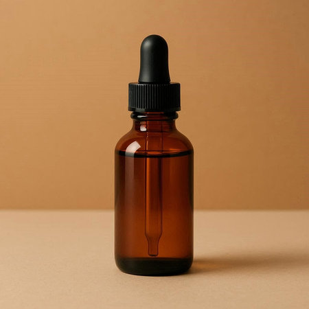 Amber glass dropper bottle with pipette on beige background