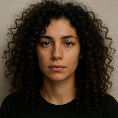 Portrait of a young woman with curly hair looking at the cameraの写真素材