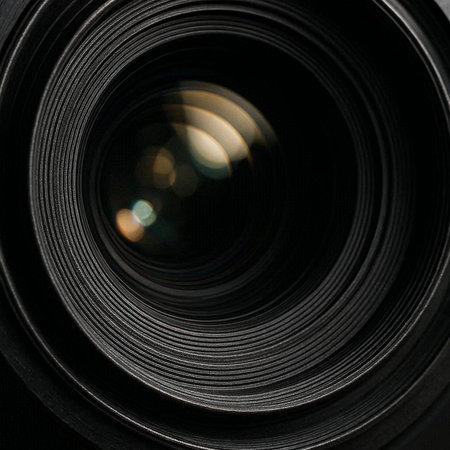 Close up of a camera lens with bokeh on black background