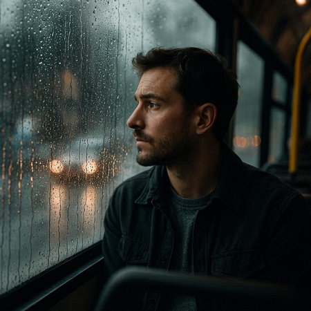 Portrait of a man sitting on a bus in the rain.