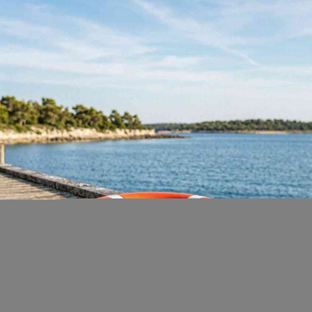 Orange lifebuoy on a pier on a sunny day. High quality photo