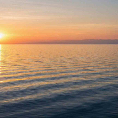 Beautiful sunset in the sea. The sun is reflected in the water.