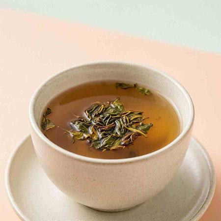 Green tea in a ceramic bowl on a pink and beige background