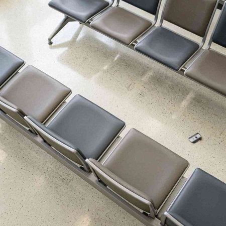 Waiting area of an airport with chairs and waiting room for flight