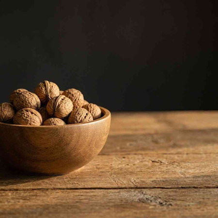 Walnuts in a wooden bowl on a wooden background. Copy space.