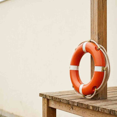 Lifebuoy on a wooden deck on a sunny day with copy space