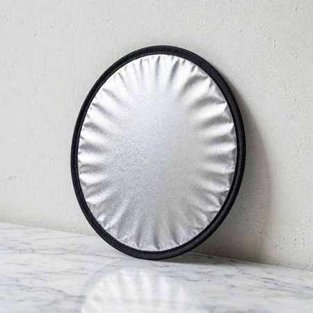 Round mirror on a white background. Close-up. Selective focus.