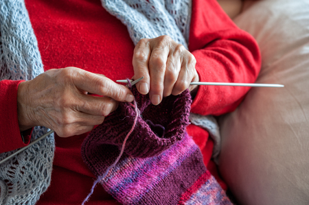 old woman knitting, sitting in her armchairの写真素材