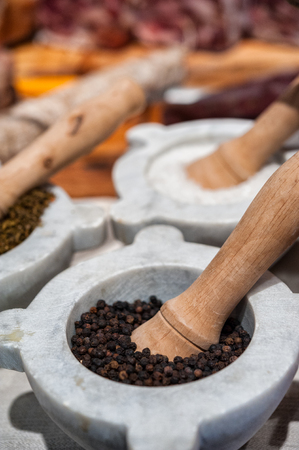 A mortar full of grains of black pepperの写真素材