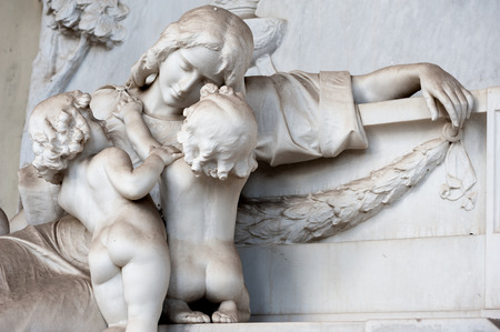 The sons console the afflicted mother who weeps at the tombの写真素材