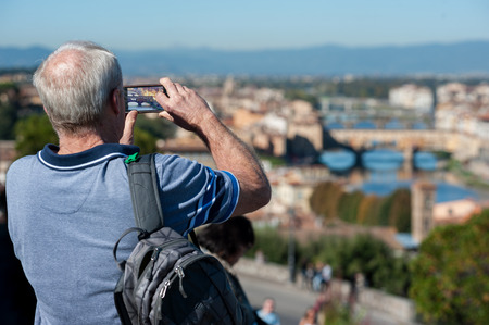 Tourist takes a panoramic photo with his smartphone