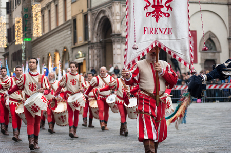 Florence, Tuscany, Italy - January 6, 2018: Standard bearer and drummer in traditional red and white costumes, with historical coat of arms of Florence, parades in the Piazza Duomo, during the historical recreation of theのeditorial素材