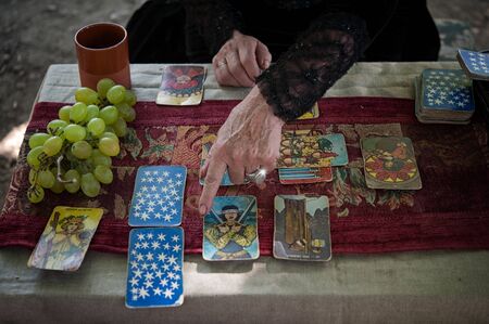 Volterra, Italy - 2019, August 11: Occult priest during a private session. Tarot readings is an ancient form of divination and prediction of the future.のeditorial素材