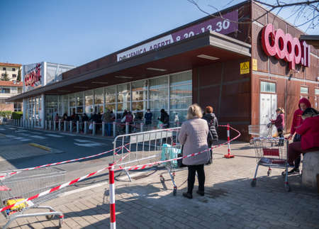Florence, Italy - 2020, April 4: European consumers in line at the supermarket for grocery shopping,...