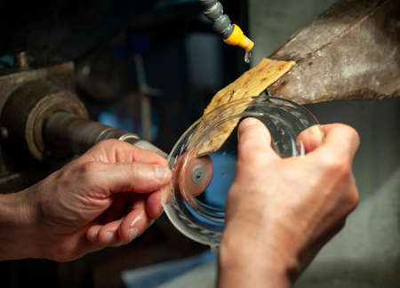 The craftsman makes small incisions on a plate. Traditional glass grinding technique.の写真素材