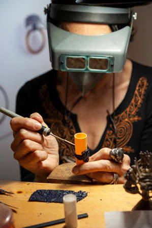Goldsmith woman at work in his workshop. .の写真素材