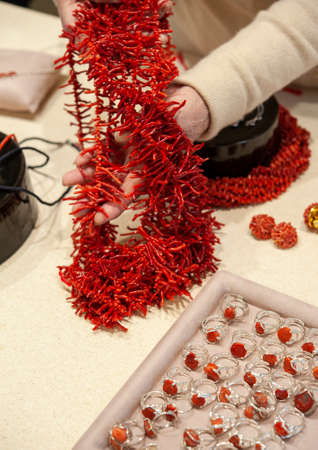 Red coral necklace and silver rings, showing on the jewelers table..の写真素材