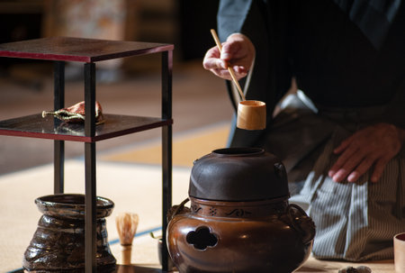 Japanese senior man in traditional kimono, during the tea ceremony. Black background..の写真素材