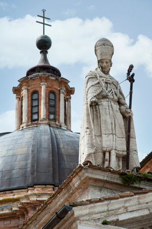 Urbino, Italy - 2023, May 5: Saint Agostino statue, on the Santa Maria Assunta cathedral roof. In the background, the dome.の写真素材