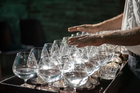 Certaldo, Italy - 2023, Jul 12: Musician plays a series of crystal glasses which make up a rare instrument called the glass harp..の写真素材