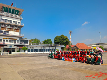 Surabaya, Indonesia - August 20, 2023 : Students sitting together taking pictures together during a study tour at Juanda Airport in Surabaya, East Java, Indonesia.のeditorial素材