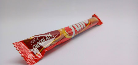 Nganjuk, Indonesia - July 10, 2023 : A very attractive display of chocolate waffer sticks in red packaging on a white background. Delicious and makes the mood happyのeditorial素材