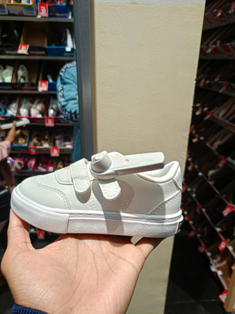 The father is holding the children's shoes. Closeup of children's shoes. Children's shoes in Men's hands.のeditorial素材