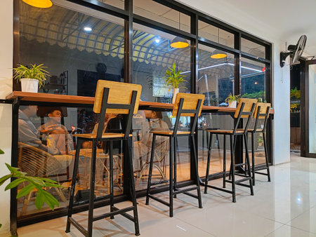 Kediri, Indonesia - August 26, 2023 : 4 chair counter bar in coffee shop and glass wall. Coffee shop interior design With chairs and glass wallsのeditorial素材