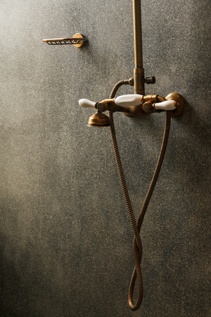 vintage brass douche or faucet and soap holder on grey concrete backgroundの写真素材