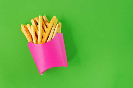 French fries in pink paper box on lime green backgroundの写真素材