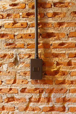 Dark brown light switches on brick wallの写真素材