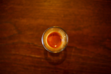 Top view of an espresso shot with coffee crema layer on wooden table background with blank copy spaceの写真素材