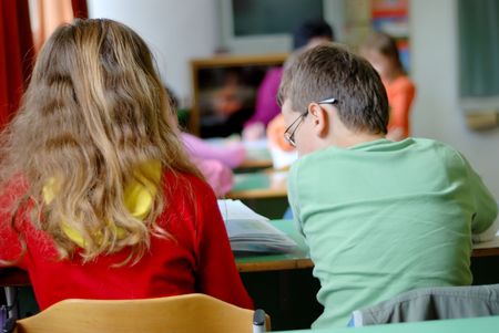 Mail and female two children learning at the school deskの写真素材