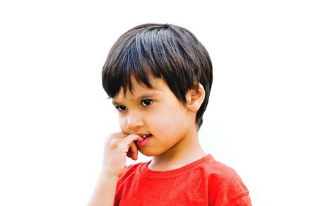A little cute kid bits his finger nailsの写真素材