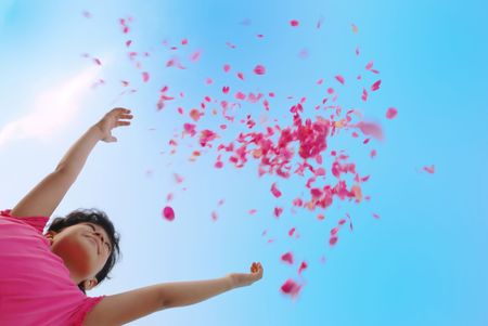 Girl droping petal of roses in airの写真素材