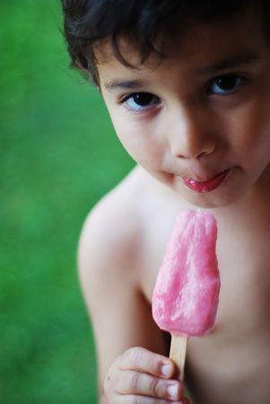 A little kid is sucking an ice creamの写真素材