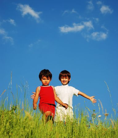 Happy unforgetable childhood on green meadow against blue skyの写真素材