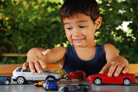 Children playing with cars toys outdoor in summer timeの写真素材