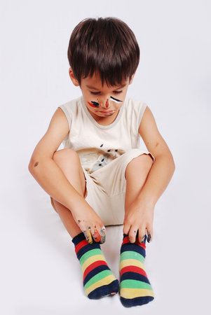 Little cute kid with colors on his faceの写真素材