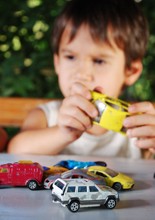 Children playing with cars toys outdoor in summer time