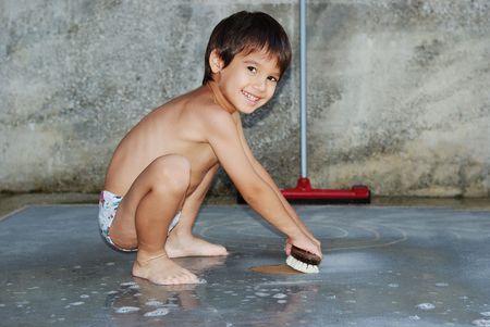 Children playing and workin, cleaning a carpet outdoorの写真素材