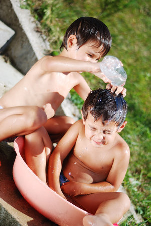Very cute child playing with water outdoorの写真素材