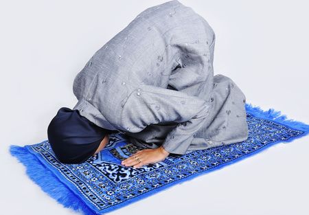 Young muslim woman praying on traditional wayの写真素材