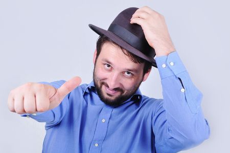 Young man with hat and pointing with his thumb upの写真素材