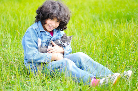 Very cute little girl with cat on meadowの写真素材