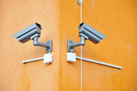 Two security cameras on orange building