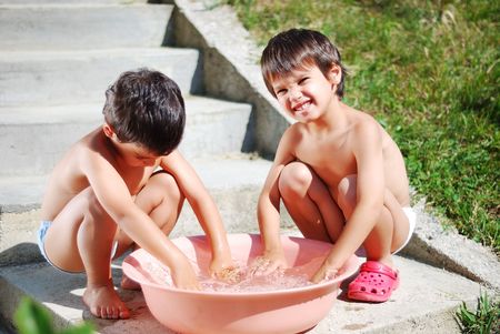 Very cute child playing with water outdoorの写真素材