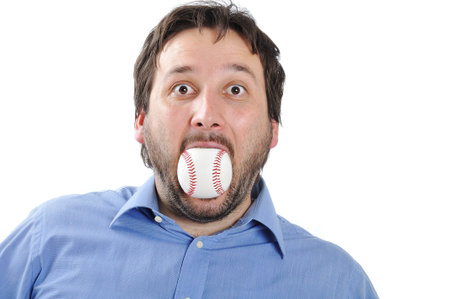Young man with baseball ball in mouthの写真素材