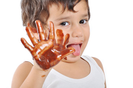 Little cute kid with chocolate on face and handsの写真素材